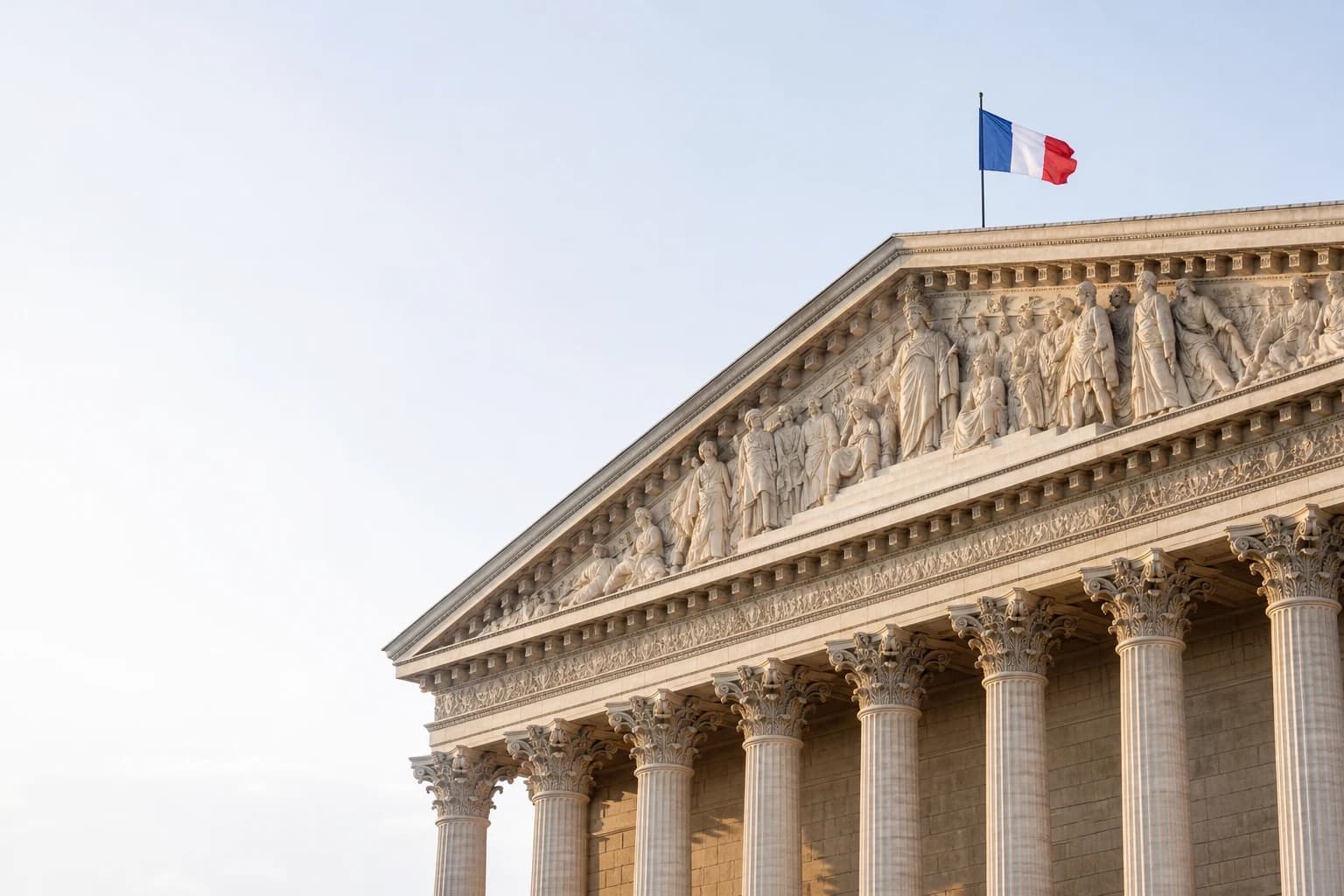 Façade d'un bâtiment civique français surmontée du drapeau tricolore